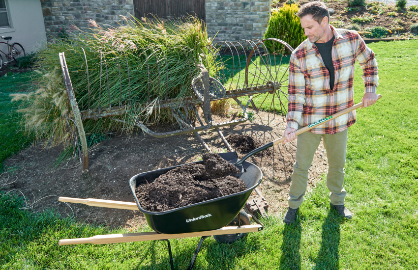 man laying mulch in garden