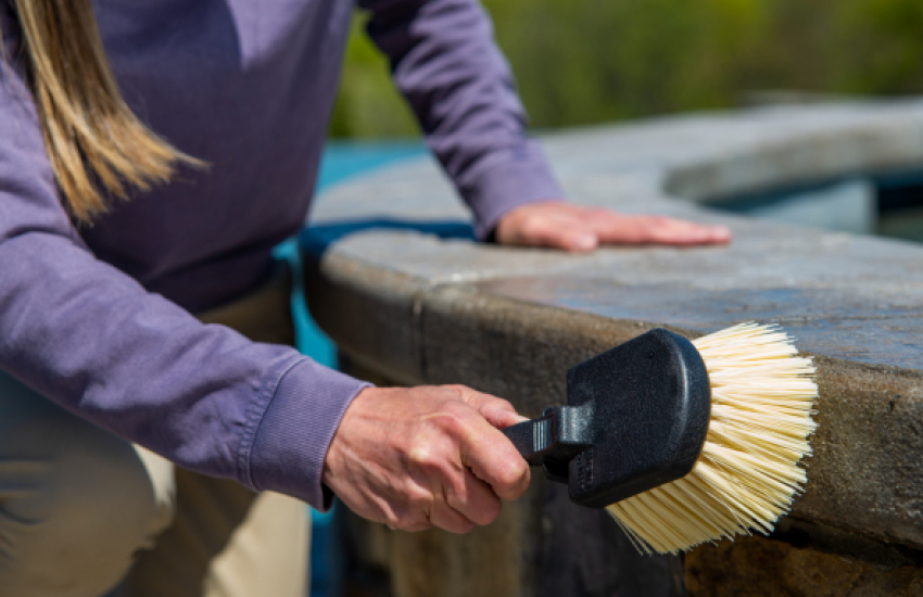 woman scrubbing stone with a brush